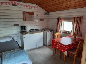 a small kitchen with a table and a table and a table and chairs at Camp Route 45 in Hammerdal