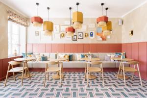 a restaurant with a couch and tables and chairs at Villa Alma - a lakeside Boutique Hotel in Sankt Gilgen
