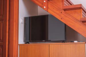 Elle comprend une télévision à écran plat installée au-dessus d'une armoire. dans l'établissement Olajos Apartman, à Berekfürdő
