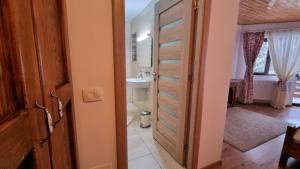 a bathroom with a door leading to a sink at La Vulturi in Fundata +31 photos