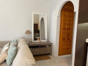 a living room with a couch and a mirror at Apartamento Veradulce, Vera Playa in Vera