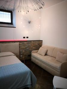 salon z kanapą i zegarem na ścianie w obiekcie La Porta Rossa w mieście Vado Ligure