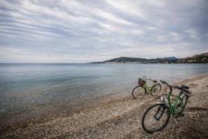 two bikes parked on a beach near the water at The Olive Yard in Gythio