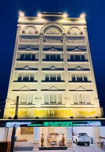 ein hohes weißes Gebäude mit einem Hotelschild drauf in der Unterkunft Royal Hotel 2 in Bạc Liêu