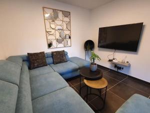 a living room with a blue couch and a flat screen tv at villa , quartier Pinède au Cap d'Agde in Cap d'Agde