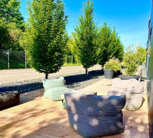 a patio with three chairs and trees in a yard at Guestroom by "FARBGESTALT" in Sarstedt