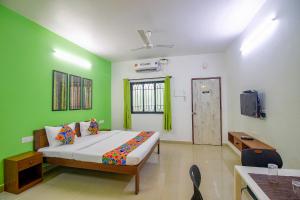 a bedroom with a bed and a green wall at FabEscape SK Studios With Pool & GYM, Arpora in Arpora