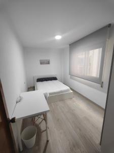 um pequeno quarto com uma cama e uma janela em TRAVIESAS, MANOLO MARTINEZ. em Vigo