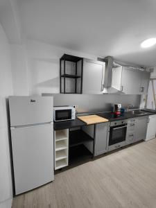uma cozinha com electrodomésticos brancos e um frigorífico branco em TRAVIESAS, MANOLO MARTINEZ. em Vigo