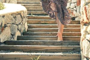 a woman is walking up the stairs at The Olive Yard in Gythio