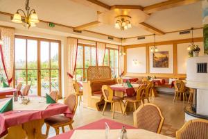 ein Restaurant mit Tischen, Stühlen und Fenstern in der Unterkunft Hotel und Berggasthof Zum Sonnenhof in Sorge