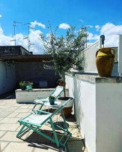 un patio con una silla, una mesa y un jarrón en beddhra mia, en Lecce