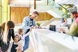 un homme et une famille debout autour d'une réception dans l'établissement Caprioara Spa&Wellness Resort, à Covasna