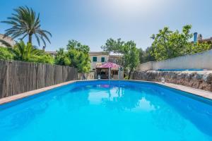 une grande piscine bleue en face d'une maison dans l'établissement Casa La Limonera. Townhouse with pool for up to 6 persons in Santanyi, à Santanyí