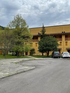 a yellow building with two cars parked in front of it at Casa con vista in Corniolo