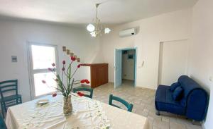 a living room with a table and a blue chair at Santu Juanne -Ammentos Posada- a due passi dalla spiaggia in San Giovanni