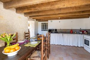 eine Küche und ein Esszimmer mit einem Tisch und Obst darauf in der Unterkunft Le Moulin de Granzay in Granzay