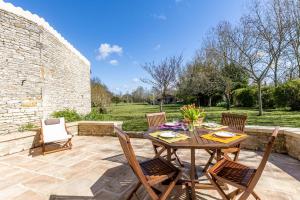 eine Terrasse mit einem Holztisch und Stühlen auf einer Terrasse in der Unterkunft Le Moulin de Granzay in Granzay