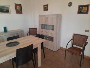 Casa di Max في توري ديل أورسو: غرفة طعام مع طاولة وكراسي خشبية