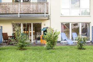 una casa con sillas azules en un patio en Haus Meeresbrise - Ferienwohnung 04 Strandnah, en Juliusruh