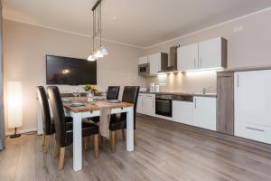 a kitchen and dining room with a table and chairs at Haus Meeresbrise - Ferienwohnung 04 Strandnah in Juliusruh