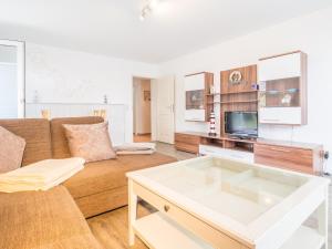 a living room with a couch and a tv at Ferienwohnung Naurulokki in Baabe