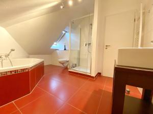 a bathroom with a tub and a shower and a sink at Ferienhaus Sabrina in Sassnitz +11 photos