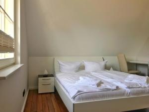 グロヴェにあるFerienhaus Sarcanderのベッドルーム1室(白いシーツ付きのベッド1台、窓付)