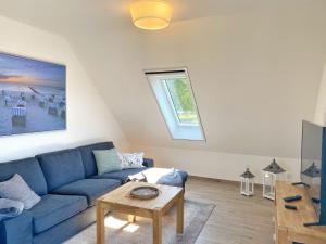 ein Wohnzimmer mit einem blauen Sofa und einem Tisch in der Unterkunft Polchow Ferienhaus, Ferienwohnung OG in Polchow