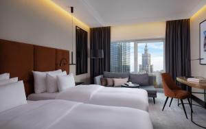 a hotel room with two beds and a desk at Radisson Collection Hotel, Warsaw in Warsaw +138 photos