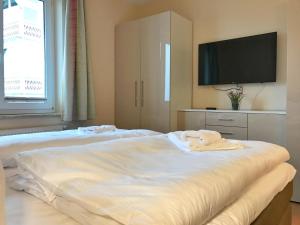 2 Betten in einem Zimmer mit einem TV und einem Bettvisor in der Unterkunft Villa Seeblick - Ferienwohnung 407 in Sassnitz