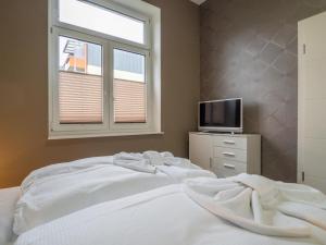 een slaapkamer met een wit bed en een raam bij Sassnitz Villa Gössel, WE 3 RZV in Sassnitz