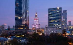 Radisson Collection Hotel, Warsaw في وارسو: أفق المدينة في الليل مع المباني الطويلة