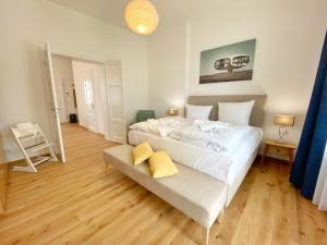 a bedroom with a large white bed and wooden floors at Villa Jenny - Ferienappartement 1 mit Meerblick in Sassnitz