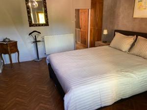Un dormitorio con una gran cama blanca y una mesa. en Gite de la dime, en Ribeauvillé