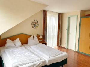 a bedroom with a bed with white sheets and pillows at Wiek Hafenresidenz App 35 RZV in Wiek auf Rügen 