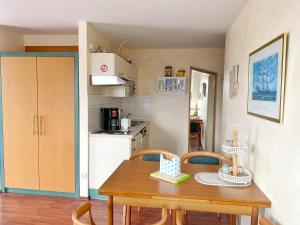 a small kitchen with a wooden table and chairs at Wiek Hafenresidenz App 35 RZV in Wiek auf Rügen 