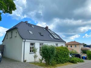 uma casa branca com um telhado preto em Ferienwohnung am Nationalpark em Sassnitz