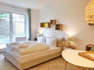 ein Schlafzimmer mit einem Bett und einem Tisch und einem Fenster in der Unterkunft Komfortappartement Kopenhagen in Sassnitz