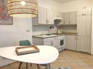 eine Küche mit einem weißen Tisch und einer weißen Arbeitsplatte in der Unterkunft Komfortappartement Kopenhagen in Sassnitz