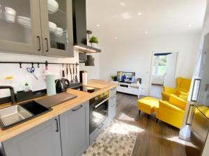 a kitchen and living room with a yellow couch at Gross Stresow Ferienwohnung Vilm E in Groß Stresow