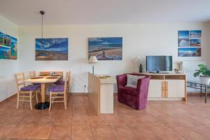 ein Wohnzimmer mit einem Tisch, einem Stuhl und einem TV in der Unterkunft Neddesitz - Ferienappartement Nr. 35 - RZV in Neddesitz