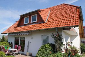 een wit huis met een oranje dak bij Ferienhaus Windberg in Sassnitz