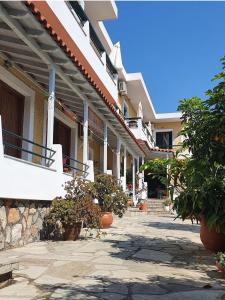 a group of buildings with potted plants in front of them at Gioula's Residence in Patitiri