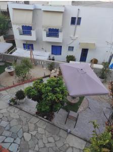 einem Regenschirm und Bänken vor einem Gebäude in der Unterkunft Gioula's Residence in Patitiri