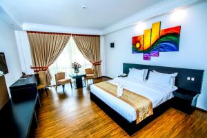 a hotel room with a bed and a colorful painting on the wall at The Covanro Airport Hotel - Katunayake in Gampaha