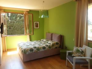 1 dormitorio con paredes verdes, 1 cama y ventana en Villa Dammusello, en Marsala