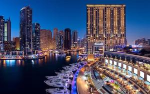 a city skyline with boats in the water at night at Address Dubai Marina - 1B Apt, Full Marina View with 5 Star Hotel Facilities by Gardenia Suites in Dubai