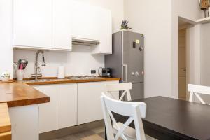 a kitchen with white cabinets and a stainless steel refrigerator at BnButler - Riccardo Galli - Incantevole Appartamento, Come a Casa Vostra! in Milan