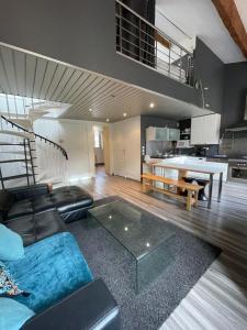 a living room with a black couch and a kitchen at 2 bedroom duplex apartment in the center of Cannes in Cannes